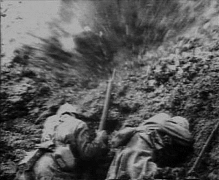 Soldiers take cover from an exploding shell.