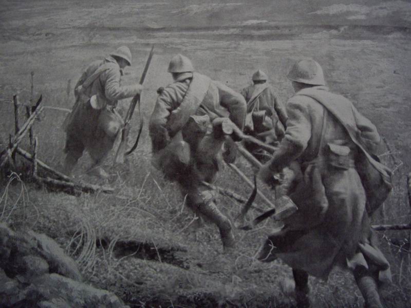 A group of soldiers dashes through a gap in the French wire.
