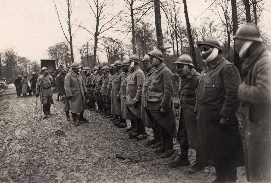 These men submit to an inspection to ensure they put their P2s and goggles on correctly, ca. late 1915.
