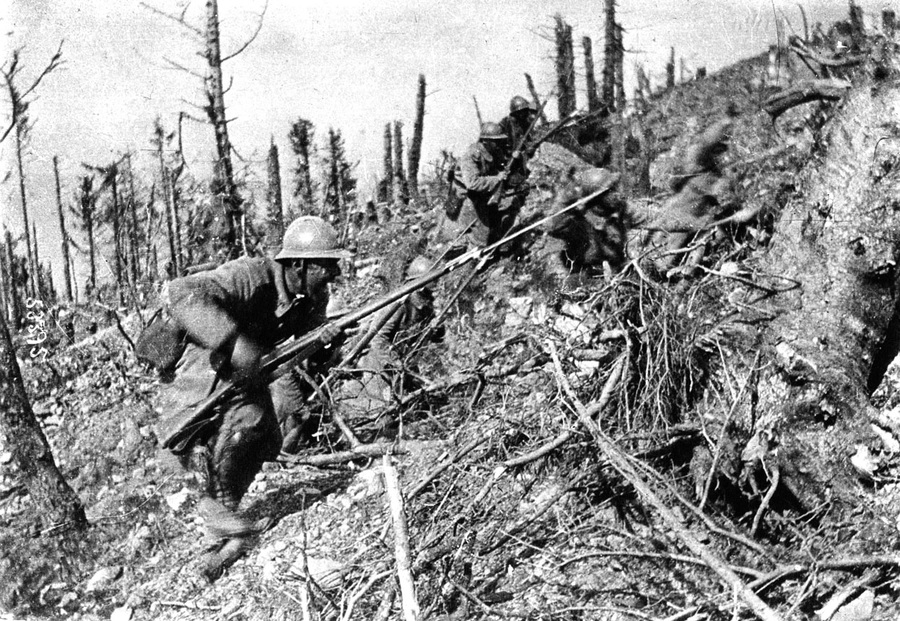 Combat photo of French troops (possibly 152 RI) advance up the scarred slope of a hill in the Argonne.