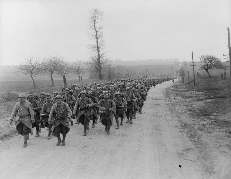 A column of French infantry on the march with the band and color guard in the lead, July 1918.