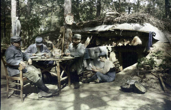Soldiers relax over some food and letters, 1915.