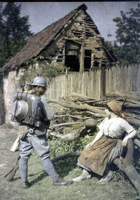 A poilu flirts with a local peasant girl. Note the rolled greatcoat on his pack.
