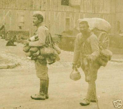 Two men loaded down with the countless canteens of their comrades.