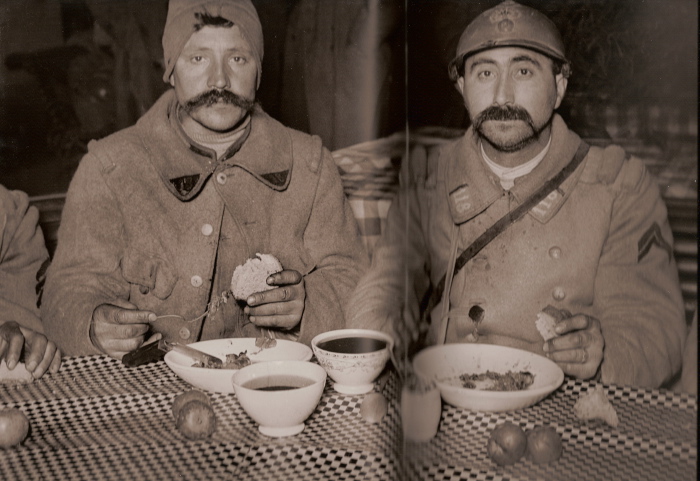 Two territorials sit down for a meal with coffee at a train station, circa 1916.