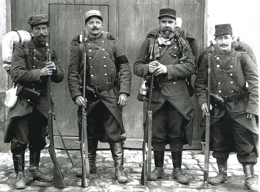 A group of old territorials, poorly equipped and armed with obsolete Gras rifles but stalwart nonetheless. One wears a mourning arm band. (1914)