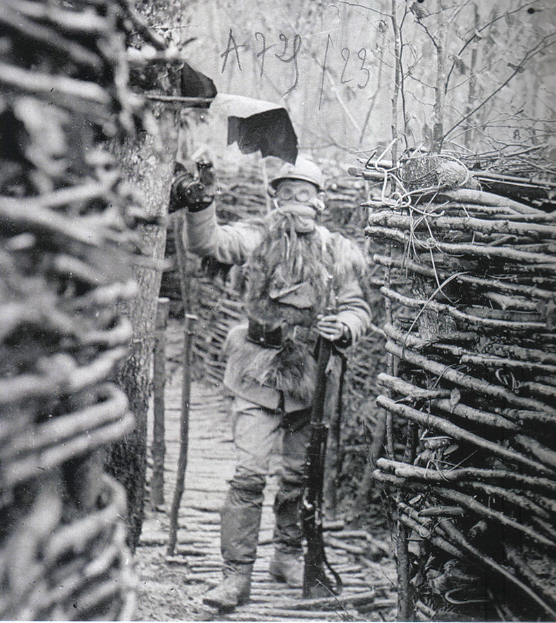 A soldier in the Parcy Forest in a gas alarm exercise, donning a P@ pad and goggles.