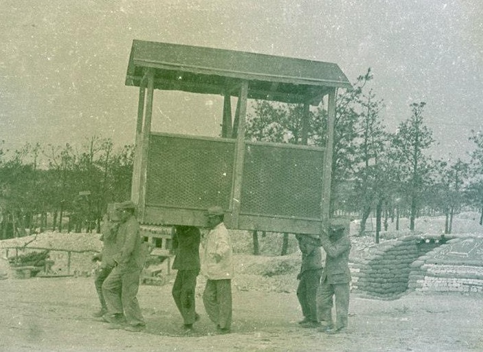 Men on a crap detail -- moving a portable latrine at camp.