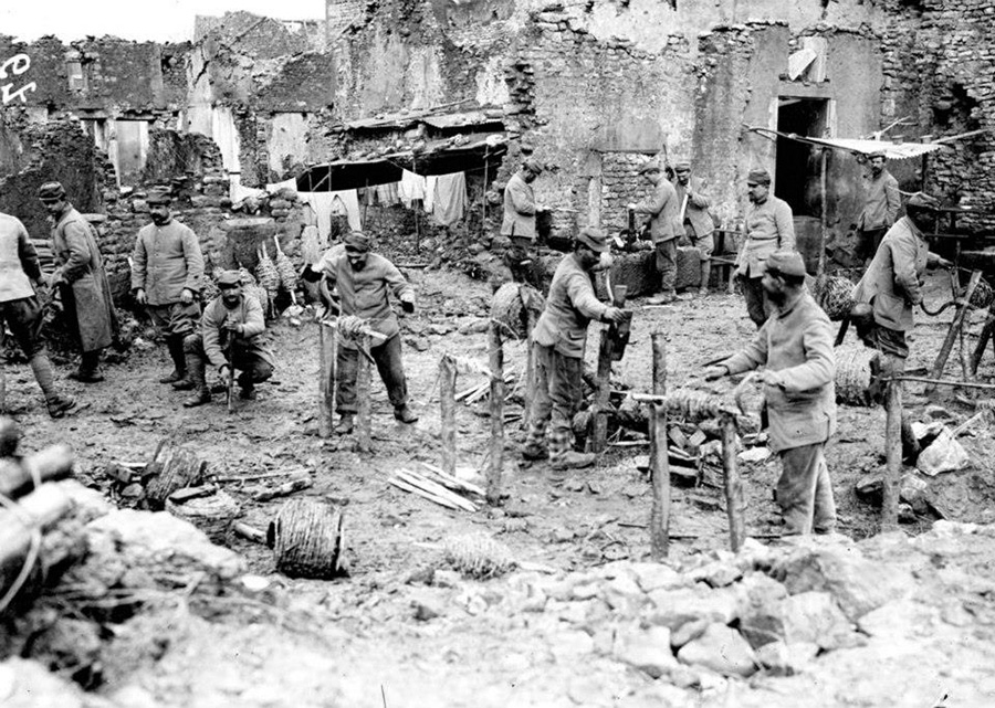 A group of territorials prepares barbed-wire bundles to be carried up to the front.