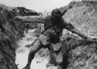 A runner attempts to pass a flooded trench. 