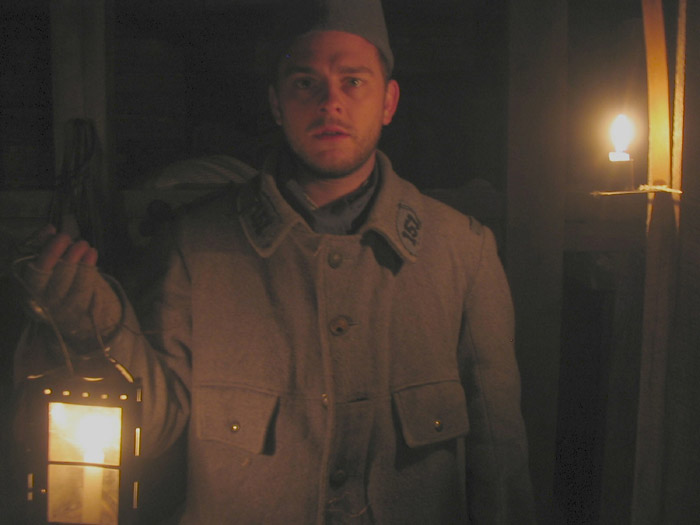 Sdt. Bracken holds a squad lantern in the bunker as he warms up from the cold, April 2005.