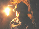 Sgt. Contamine in a small shelter uses a improvised lantern made from a sardine tin to see in the night.