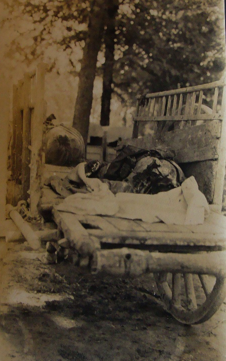 The mutilated remains of a man lies in a horse cart.