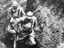 Two men carry out a wounded comrade.