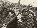 A dead French soldier half-buried in a bombardment.